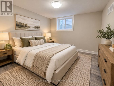 A bedroom with a large bed, a nightstand with a lamp, and a painting on the wall.