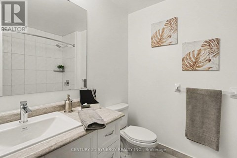 A bathroom with a toilet, sink, and towel.