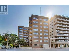 A large apartment building with a sunny sky in the background.