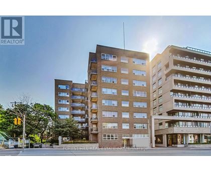 A large apartment building with a sunny sky in the background.
