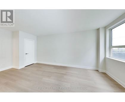A room with a white door and a window with a view of the street.