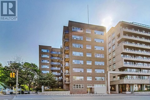 A large apartment building with a sunny sky in the background.