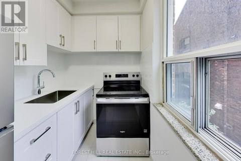 A kitchen with white cabinets and a black stove top oven.