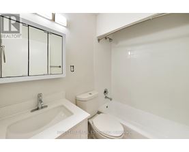 A white bathroom with a sink, toilet and bathtub.