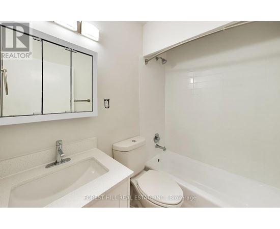 A white bathroom with a sink, toilet and bathtub.