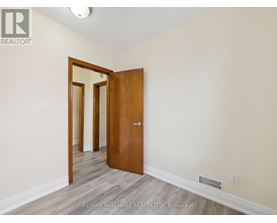 A room with a wooden door and a mirror on the wall.