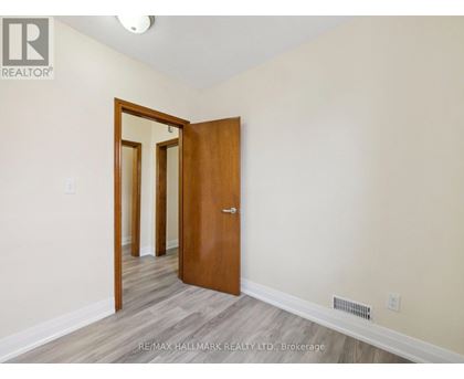 A room with a wooden door and a mirror on the wall.