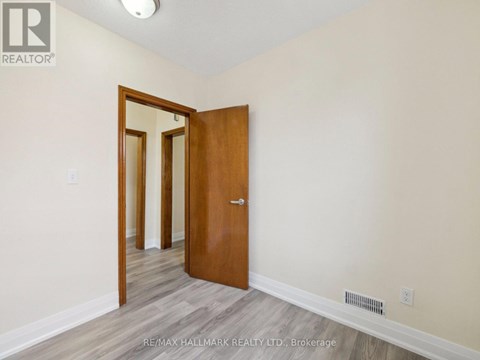 A room with a wooden door and a mirror on the wall.