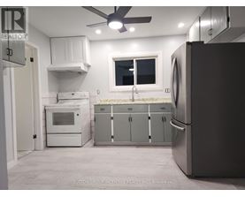 A kitchen with a refrigerator, oven, and microwave.