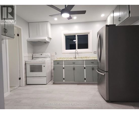 A kitchen with a refrigerator, oven, and microwave.