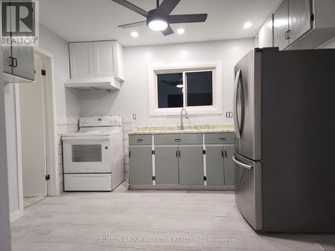 A kitchen with a refrigerator, oven, and microwave.