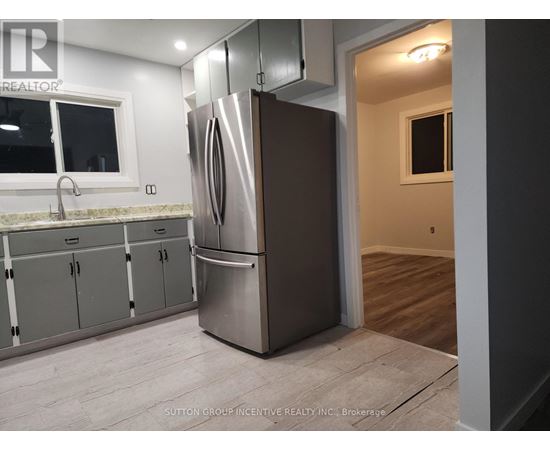 A kitchen with a stainless steel refrigerator and cabinets.