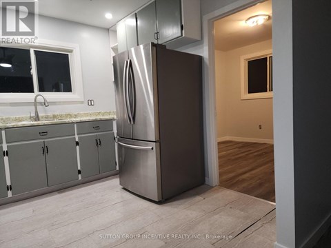 A kitchen with a stainless steel refrigerator and cabinets.
