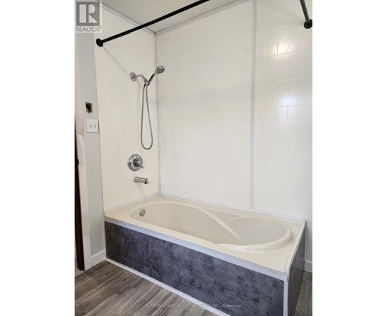 A white bathroom with a bathtub and a shower.