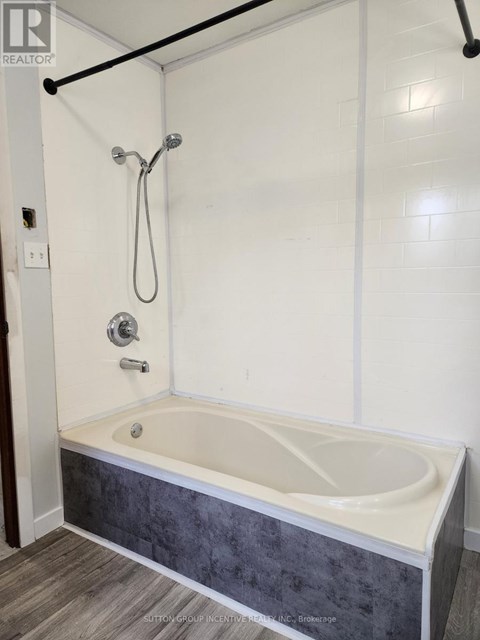 A white bathroom with a bathtub and a shower.