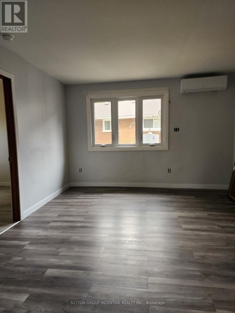 A room with a window and wooden flooring.