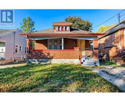 A house with a red brick facade and a white porch.