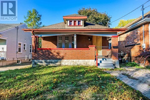 A house with a red brick facade and a white porch.