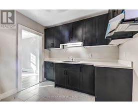 A kitchen with black cabinets and a white countertop.