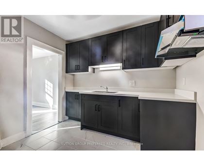 A kitchen with black cabinets and a white countertop.