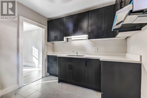 A kitchen with black cabinets and a white countertop.