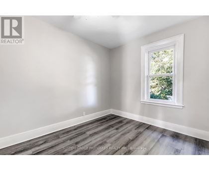 A room with a window and wooden flooring.