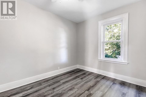 A room with a window and wooden flooring.
