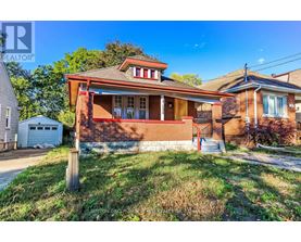 A house with a red brick exterior and a white garage door is for sale.