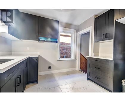 A kitchen with black cabinets and a white counter top.