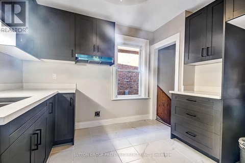 A kitchen with black cabinets and a white counter top.