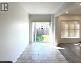 A spacious room with a sliding glass door leading to a backyard.