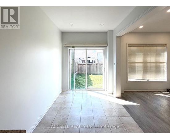 A spacious room with a sliding glass door leading to a backyard.