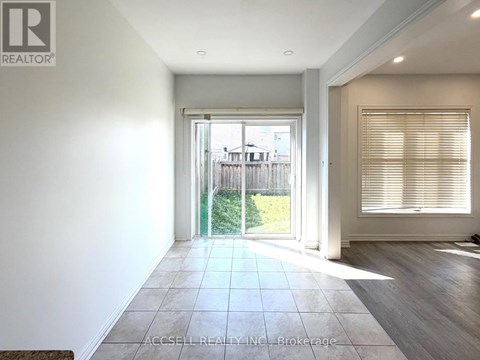 A spacious room with a sliding glass door leading to a backyard.