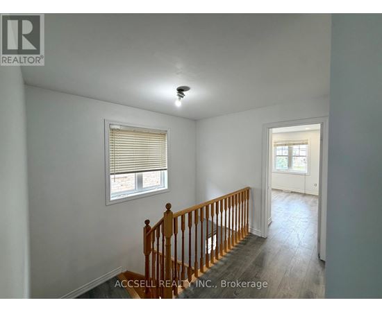 A room with a wooden staircase and a window with blinds.