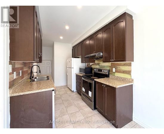 A kitchen with brown cabinets and a granite counter top.