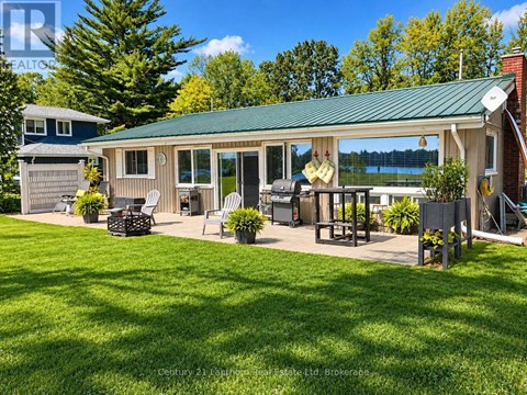 A house with a green roof and a deck with chairs.