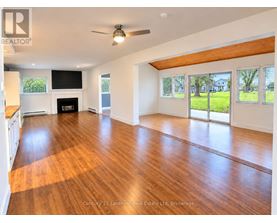 A spacious room with wooden floors and a fireplace.