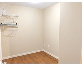 Empty room with a shelf and a wooden floor.