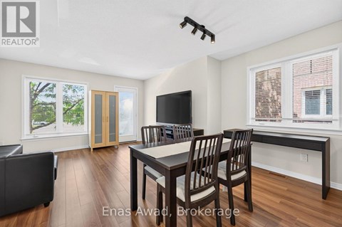 A well-lit dining room with a wooden table and chairs.