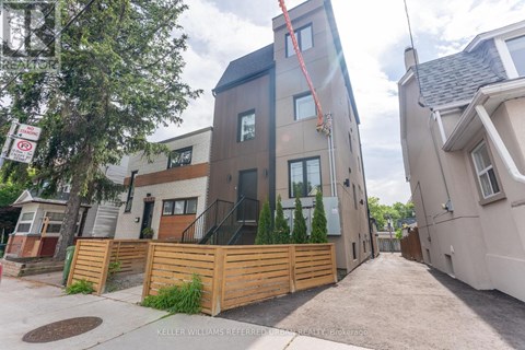 A modern two-story house with a wooden fence in front.