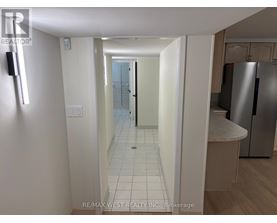 A hallway with a white door and a white wall.