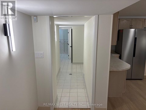 A hallway with a white door and a white wall.