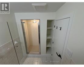 A white bathroom with a walk in shower and a white door.