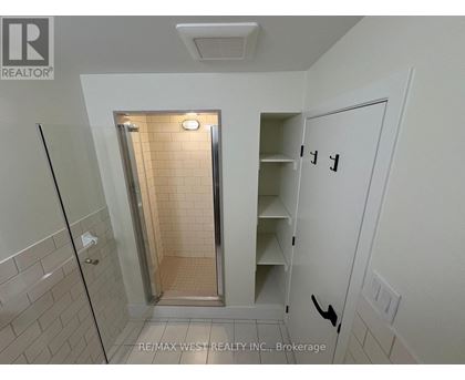 A white bathroom with a walk in shower and a white door.