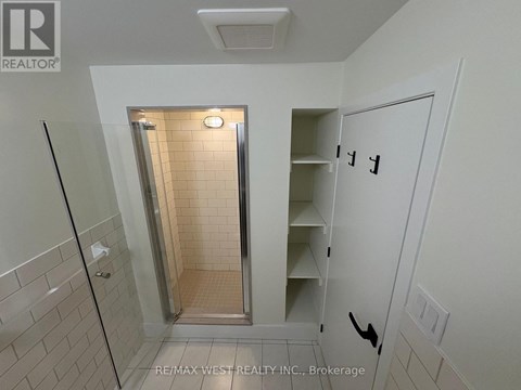 A white bathroom with a walk in shower and a white door.