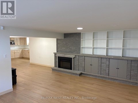 A living room with a fireplace and built-in shelves.