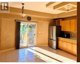 A kitchen with wooden cabinets and a stainless steel refrigerator.