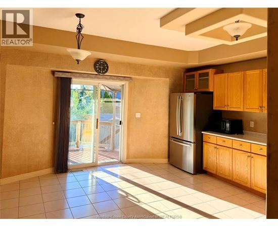 A kitchen with wooden cabinets and a stainless steel refrigerator.