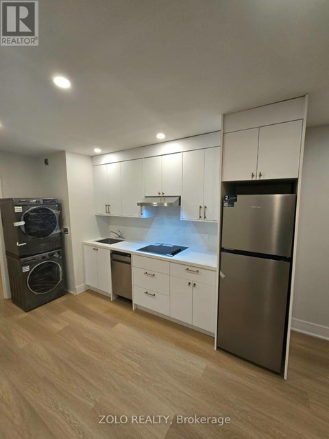 A kitchen with a washing machine and a refrigerator.