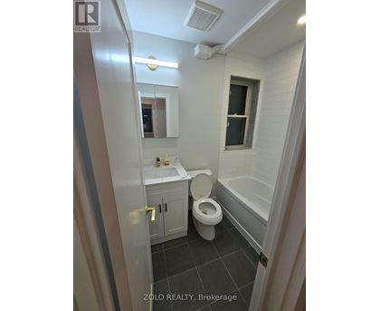 A bathroom with a toilet, sink, and bathtub.